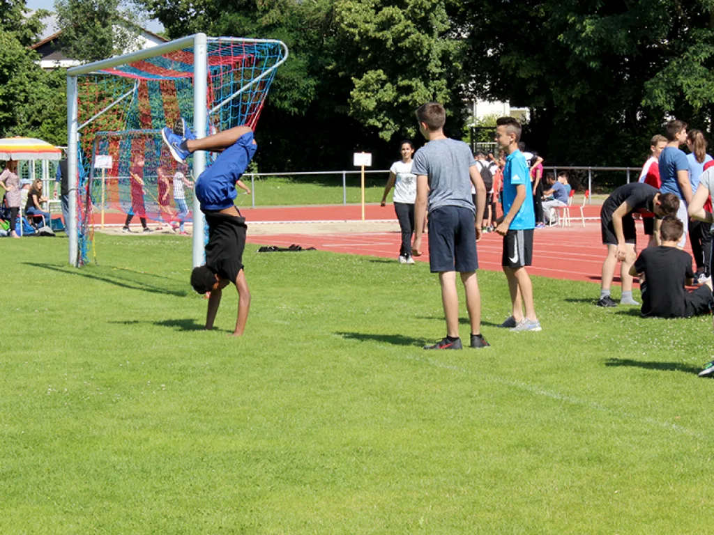 Jugendlicher wirft auf dem Rasen einen Ball.